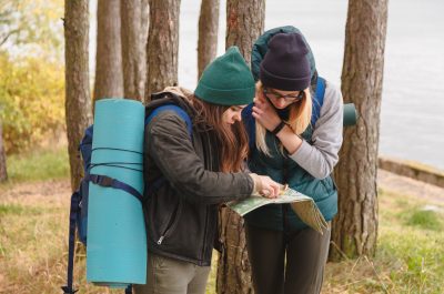 Two young tourist determine the route map and compass. Two young tourist determine the route map and compass.