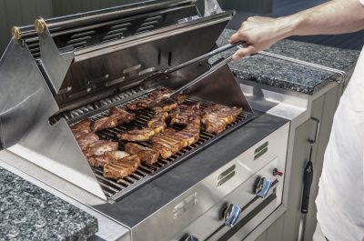 outdoor propane gas grill with man turning stakes outdoor propane gas grill with man turning stakes