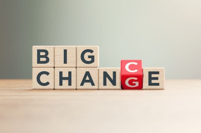 “Big Change and Big Chance” Written Red Wood Blocks Sitting on Wood Surface in Front a Defocused Background “Big Change and Big Chance” Written Red Wood Blocks Sitting on Wood Surface in Front a Defocused Background