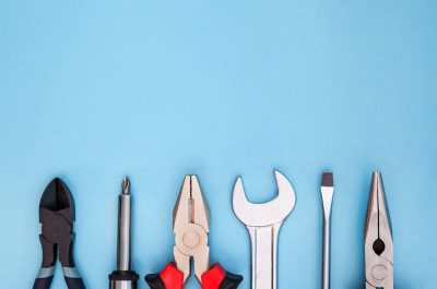 Various tools worker, hammer, wrench, screwdriver, pliers on a blue background, top view with free space Various tools worker, hammer, wrench, screwdriver, pliers on a blue background, top view with free space