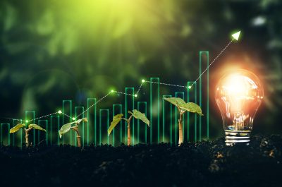 Light bulb is located on the soil, and plant are growing with growth graph.Renewable energy generation is essential in the future. Alternative sources of energy.Green energy development. Light bulb is located on the soil, and plant are growing with growth graph.Renewable energy generation is essential in the future. Alternative sources of energy.Green energy development.