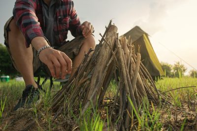 A man tourist making bonfire and set camping tent. A man tourist making bonfire and set camping tent.