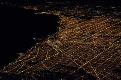 Aerial View Of Illuminated Cityscape By River At Night Aerial View Of Illuminated Cityscape By River At Night