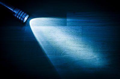 Flashlight shining a beam of light in darkness Flashlight shining a beam of light in darkness